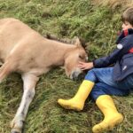 Anouk liegt im Gras mit einem Kind